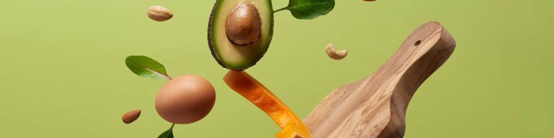 A creative arrangement of paleo diet ingredients floating above a wooden board on a green background.